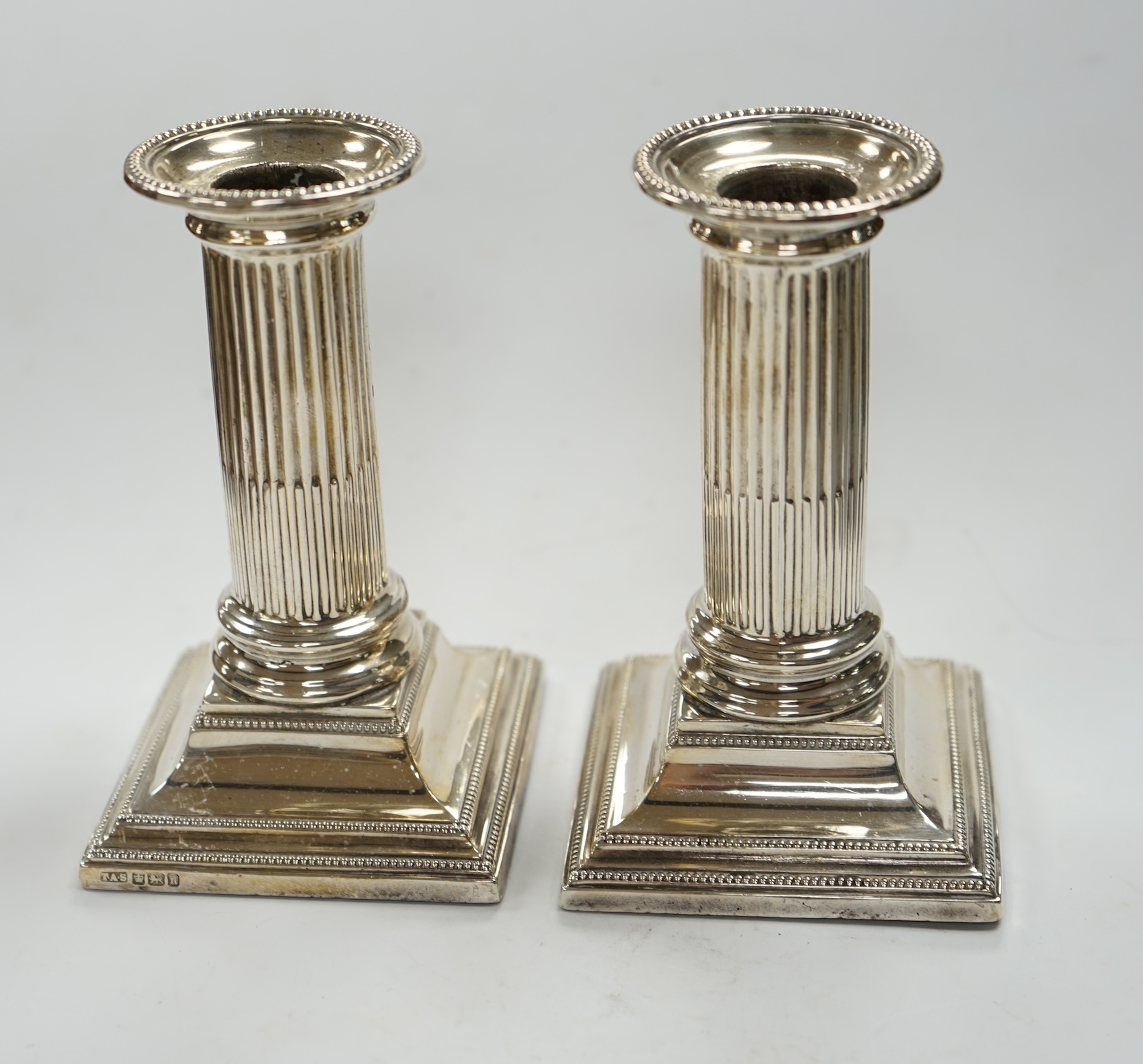 A pair of Edwardian silver dwarf candlesticks, Thomas A. Scott, Sheffield, 1905, height 12.5cm, weighted. Condition - fair